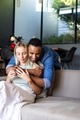 Couple embracing on sofa at home, enjoying peaceful and loving moment together - PhotoDune Item for Sale