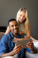 Happy couple using tablet at home, smiling and enjoying time together - PhotoDune Item for Sale