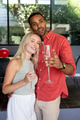Celebrating with champagne glasses, couple smiling during festive moment at party - PhotoDune Item for Sale