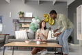 Celebrating birthday, African American man serving cake to smiling woman at home - PhotoDune Item for Sale
