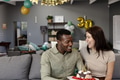Couple celebrating birthday at home with cake and balloons, sharing joyful moment - PhotoDune Item for Sale