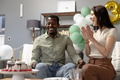 Celebrating birthday, friends clapping and smiling with cake and balloons at home - PhotoDune Item for Sale