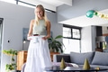 Smiling woman carrying birthday cake with candles in modern living room - PhotoDune Item for Sale