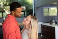 Couple smiling and embracing in modern kitchen, enjoying joyful moment together - PhotoDune Item for Sale
