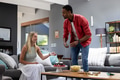 African American man serving cake to smiling woman during home celebration - PhotoDune Item for Sale