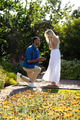 Man proposing to surprised woman in garden, surrounded by blooming flowers - PhotoDune Item for Sale