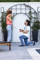 Man proposing to surprised woman outdoors, holding engagement ring, joyful moment - PhotoDune Item for Sale
