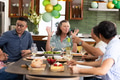 Senior friends having lively conversation with wine around dining table at home - PhotoDune Item for Sale