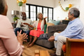Elderly friends laughing and sharing stories in cozy living room celebration - PhotoDune Item for Sale