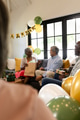 Opening gifts with family, elderly woman celebrating birthday joyfully at home - PhotoDune Item for Sale