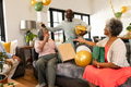 Elderly friends celebrating birthday at home with gifts and balloons, sharing joy - PhotoDune Item for Sale