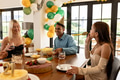 Friends celebrating at home with snacks, drinks, and festive decorations - PhotoDune Item for Sale