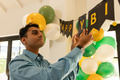 Man decorating with birthday banner and balloons, preparing for celebration at home - PhotoDune Item for Sale