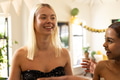 Women celebrating at home, smiling and enjoying festive decorations together - PhotoDune Item for Sale