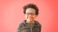 Portrait Of Smiling Young Boy Wearing Glasses Against Red Studio Background - PhotoDune Item for Sale