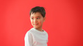 Portrait Of Young Boy Against Red Studio Background Looking Away From Camera - PhotoDune Item for Sale