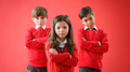 Group Of Elementary School Pupils Wearing Uniform Against Red Studio Background - PhotoDune Item for Sale
