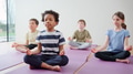 Group Of Elementary School Pupils Sitting On Floor And Meditating - PhotoDune Item for Sale