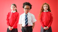 Group Of Elementary School Pupils Wearing Uniform Folding Arms Against Red Studio Background - PhotoDune Item for Sale