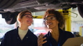 Female Tutor With Student Looking Underneath Car On Hydraulic Ramp On Auto Mechanic Course - PhotoDune Item for Sale