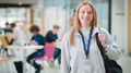 Portrait Of Smiling Female College Student In Busy Communal Campus Building - PhotoDune Item for Sale