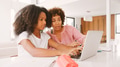 Mother Helping Teenage Daughter With Homework Using Laptop At Home Together - PhotoDune Item for Sale