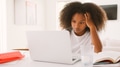 Stressed Teenage Girl Struggling With Homework Using Laptop At Home - PhotoDune Item for Sale