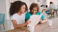 Teenage Granddaughter Reading Book With Grandmother At Home - PhotoDune Item for Sale