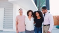 Portrait Of Smiling Family With Older Children Standing In Front Of House - PhotoDune Item for Sale