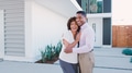 Portrait Of Smiling Mature Couple Standing In Front Of House - PhotoDune Item for Sale