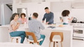 Family With Older Children Sitting Around Kitchen Counter At Home Together - PhotoDune Item for Sale