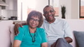 Portrait Of Loving Senior Couple Sitting On Sofa At Home Together - PhotoDune Item for Sale