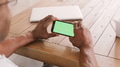 Close Up Of Senior Man Sitting At Table Using Green Screen Smart Phone - PhotoDune Item for Sale