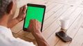 Close Up Of Senior Man Sitting At Table Using Green Screen Digital Tablet - PhotoDune Item for Sale