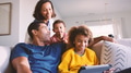 Family At Home With Father And Daughter Using Digital Tablet In Foreground - PhotoDune Item for Sale