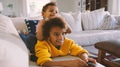 Brother And Sister Lying On Sofa At Home Watching TV Together - PhotoDune Item for Sale