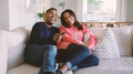 Mature Couple Sitting On Sofa At Home Watching TV Together - PhotoDune Item for Sale