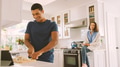 Couple In Kitchen Preparing Meal With Man Following Online Recipe On Digital Tablet - PhotoDune Item for Sale