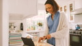 Woman In Kitchen Preparing Meal Following Online Recipe On Digital Tablet - PhotoDune Item for Sale
