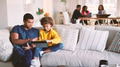 Multi Generation Family At Home With Father And Daughter Using Digital Tablet In Foreground - PhotoDune Item for Sale