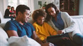 Multi Generation Family At Home With Parents And Daughter Using Digital Tablet In Foreground - PhotoDune Item for Sale