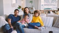 Family At Home Sitting On Sofa Watching TV Together - PhotoDune Item for Sale