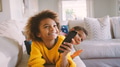 Brother And Sister Lying On Sofa At Home Watching TV Together - PhotoDune Item for Sale