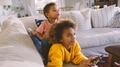 Brother And Sister Lying On Sofa At Home Watching TV Together - PhotoDune Item for Sale