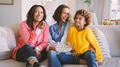 Female Multi Generation Family Sitting On Sofa At Home With Popcorn Watching TV Together - PhotoDune Item for Sale