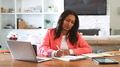 Mature Woman Sitting At Table At Home Checking Finances On Laptop - PhotoDune Item for Sale