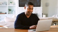 Mature Man Sitting At Table At Home Checking Finances On Laptop - PhotoDune Item for Sale