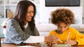 Grandmother And Granddaughter Sitting At Table At Home Drawing Picture On Digital Tablet With Stylus - PhotoDune Item for Sale
