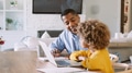 Grandfather And Granddaughter Sitting At Table Using Laptop At Home Together - PhotoDune Item for Sale