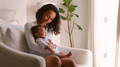 Mother Sitting On Chair In Bedroom Holding Smiling Baby Son - PhotoDune Item for Sale